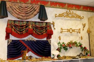 N J Rose showroom display showing a variety of valances and decorative curtain rods and brackets.